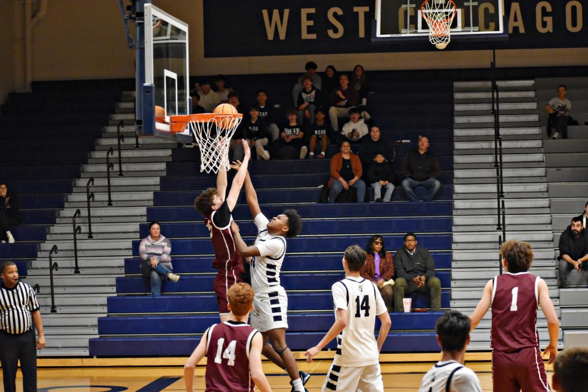 Tristan McWilliams takes his shot as Wheaton North attempts to block.