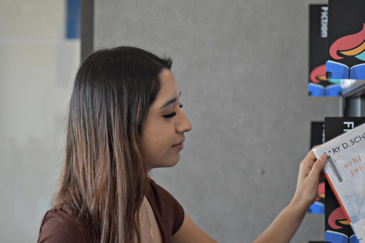 Senior Jocelyn Ruiz looks at some of the books shelved at the Learning Resource Center at West Chicago Community High School.