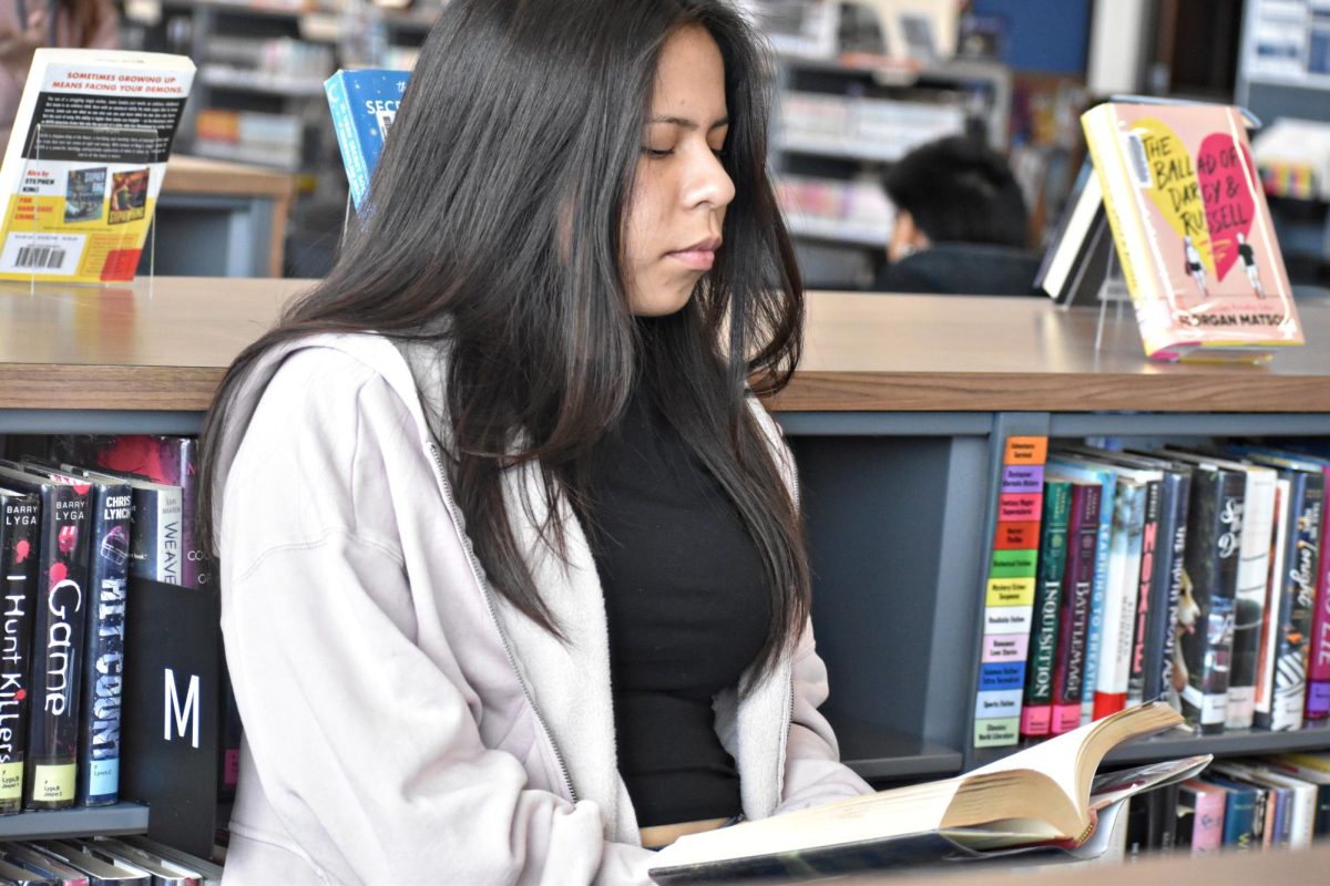 Junior Vanessa Escobar Santizo browses books in the Learning Resource Center at WCCHS in Jan. 2025.