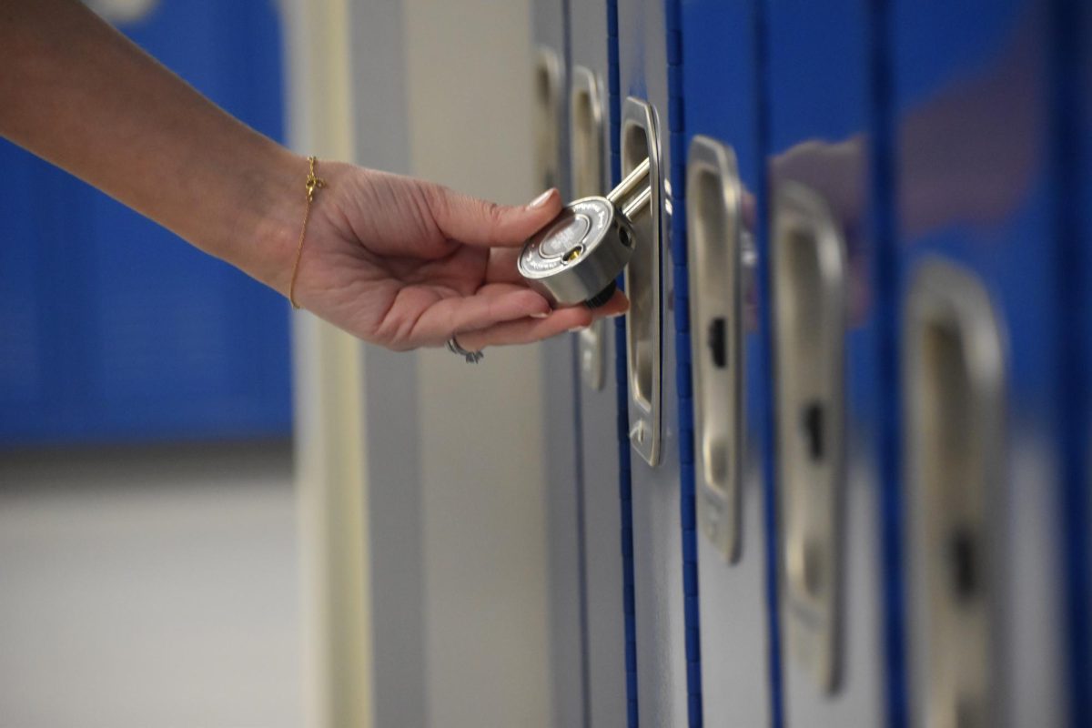 WCCHS journalism adviser Leslie Fireman examines a locker in which the lock has been placed on backwards while looking for possible news topics with her students in January 2025. 