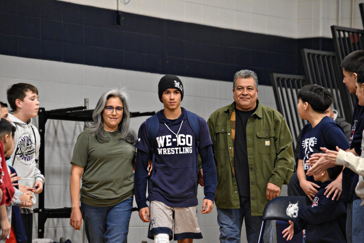 Ryan Alvarado walks out with his parents on Senior Night. Alvarado, ranked 8th in Illinois' Class 3A 126-pound division, has been a key competitor for West Chicago this season.