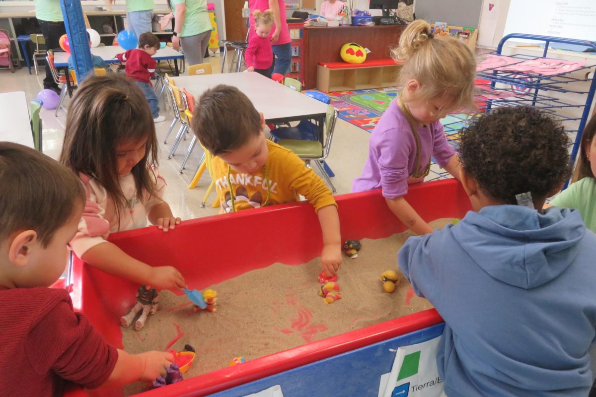 5 children contributing to the activity planned by student teachers during the Wildcat Preschool program at West Chicago Community High School which helps improve their learning and readiness.