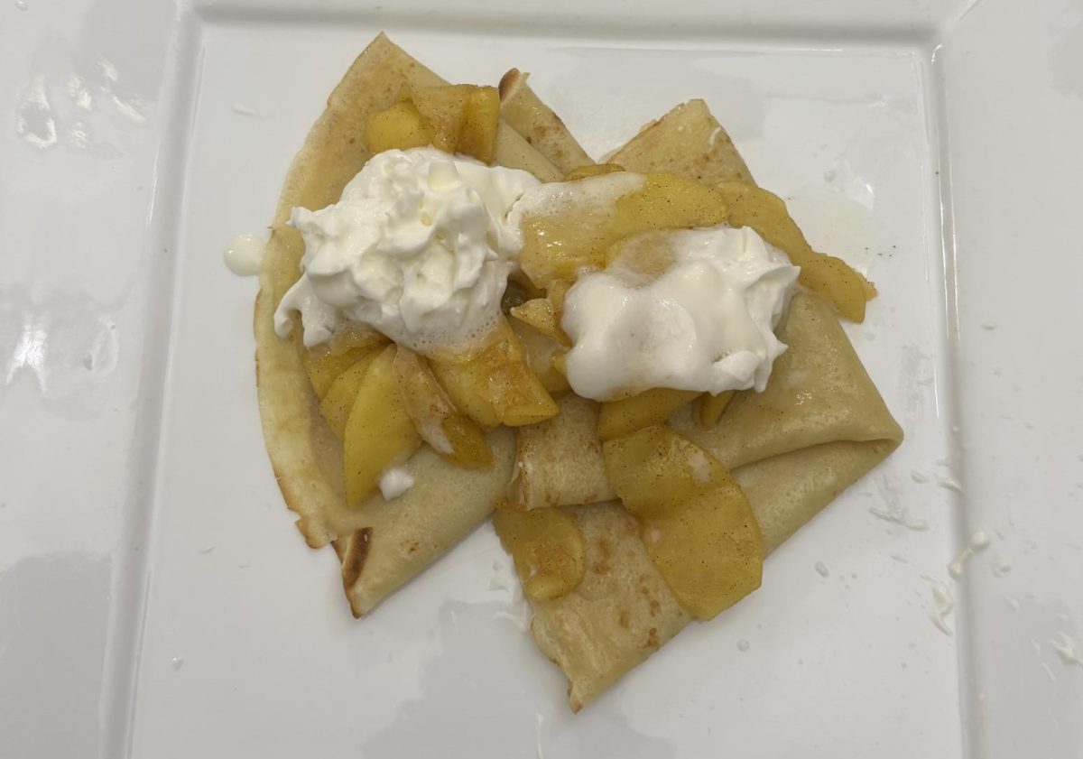 A plateful of crepes, topped with whipped cream. Crepes have a lighter texture and are less filling than pancakes.