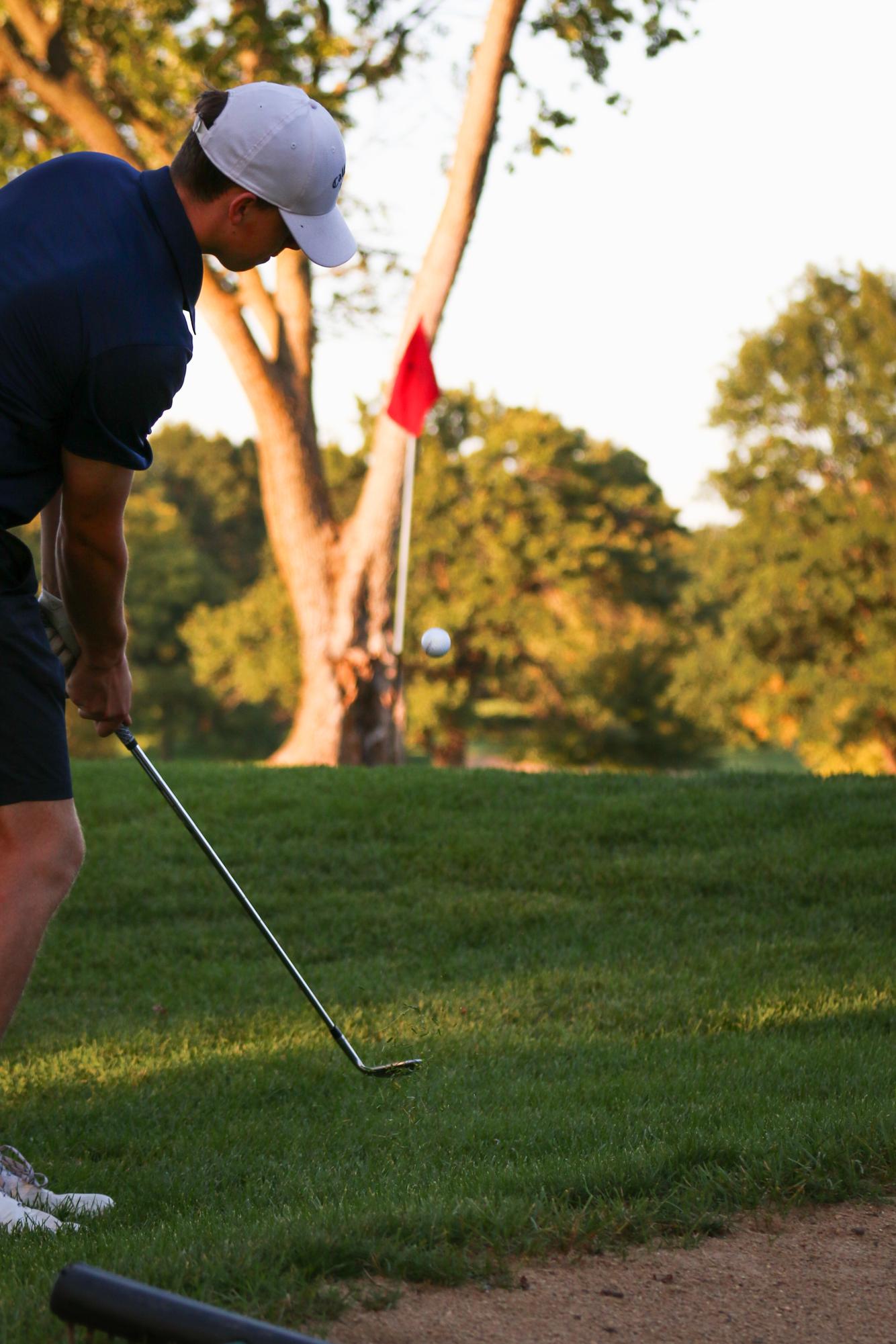 Senior Ryan Slattery hits a strong recovery shot out of the rough during the invitational. 