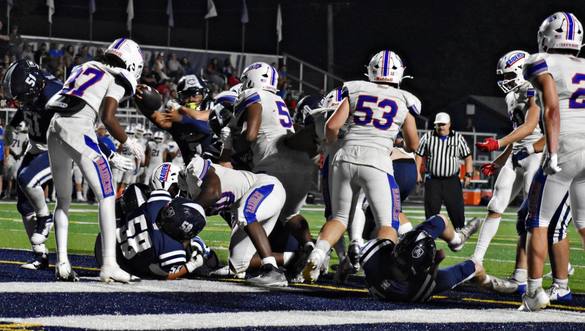 West Chicago lineman pushes through Glenbard South defenders during a goal-line play on Sept. 12.