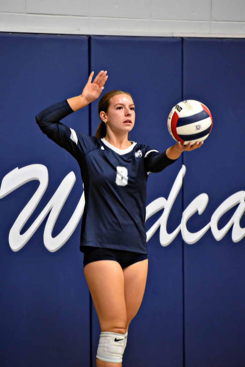 Setter Gabrielle Newell, a junior, prepares to send the ball over to Glenbard South during the Oct. 7 match in Bishop Gym. (Image has been upscaled to increase resolution.)