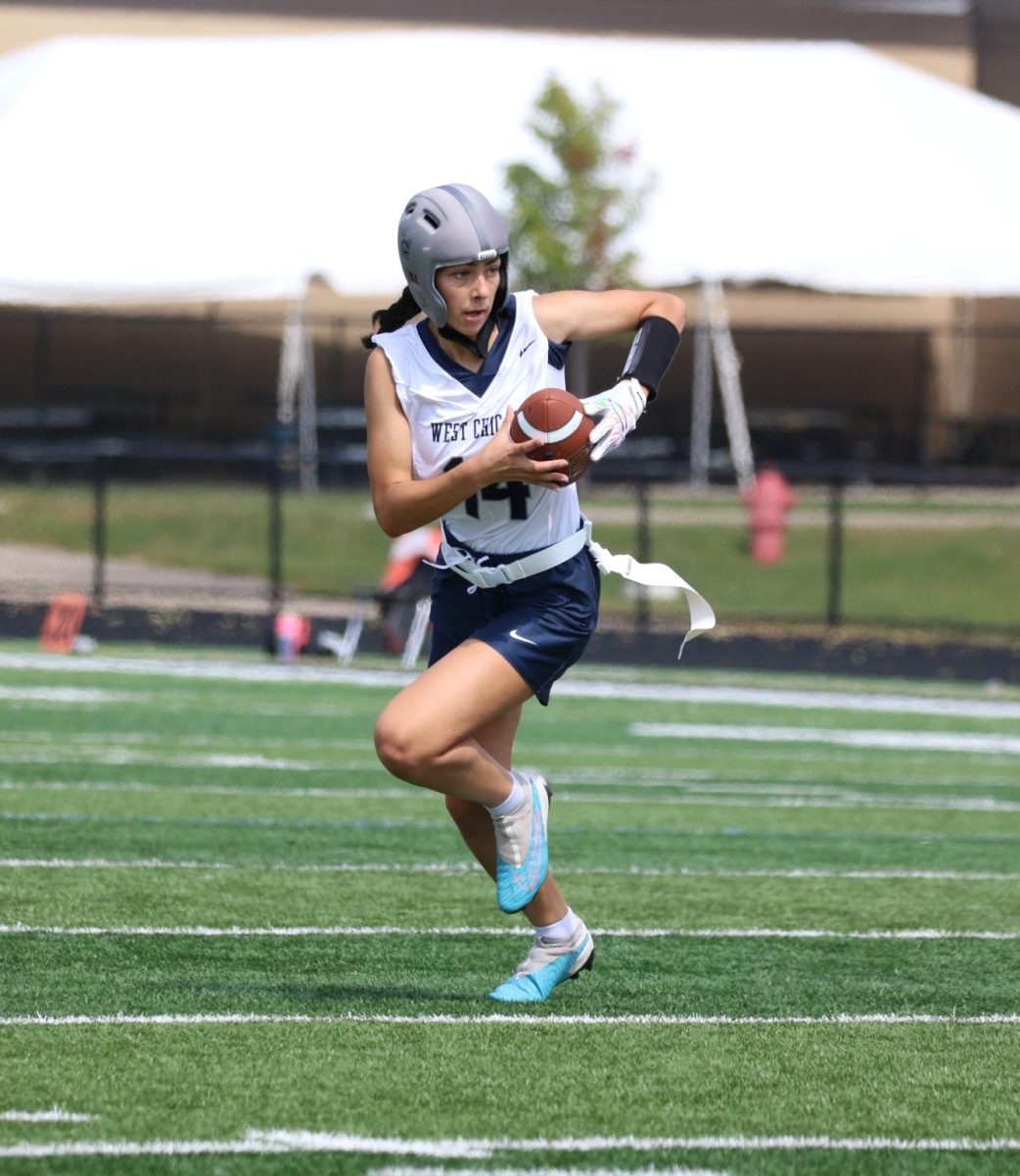 Senior Jessie Myers tears down the field with the football in her hands.