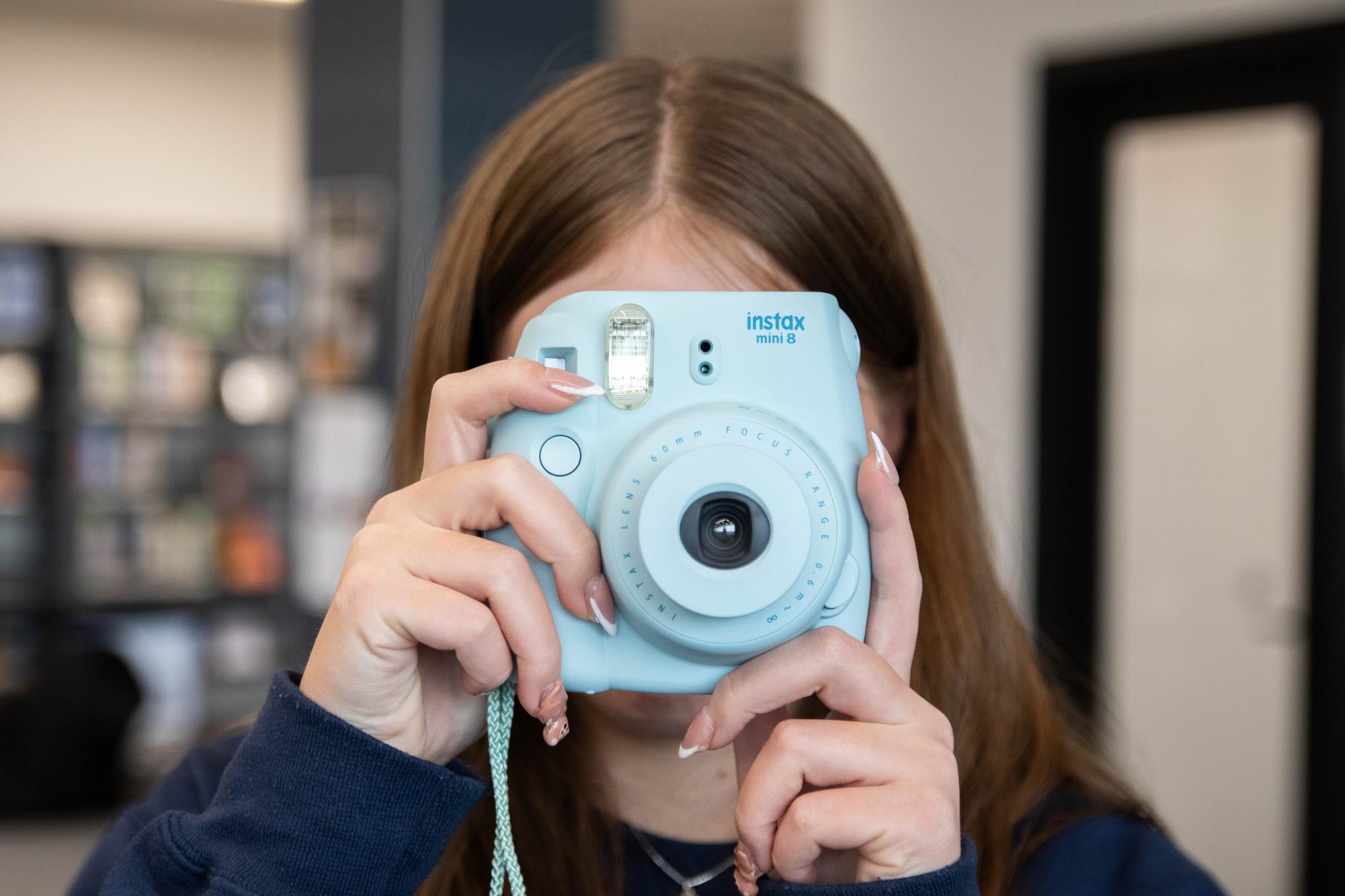 Sophomore Mary Wagner takes a photo of the photographer on an Instax Mini 8 film camera in November 2025. "Vintage [photography] captures the memories you made in the moment," Wagner said. 