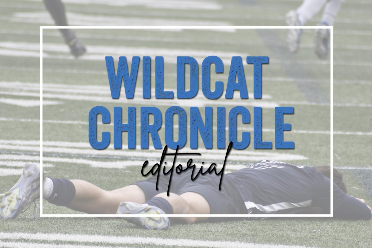 A student-athlete lies on the field during a fall game, highlighting the intense demands placed on high school athletes.