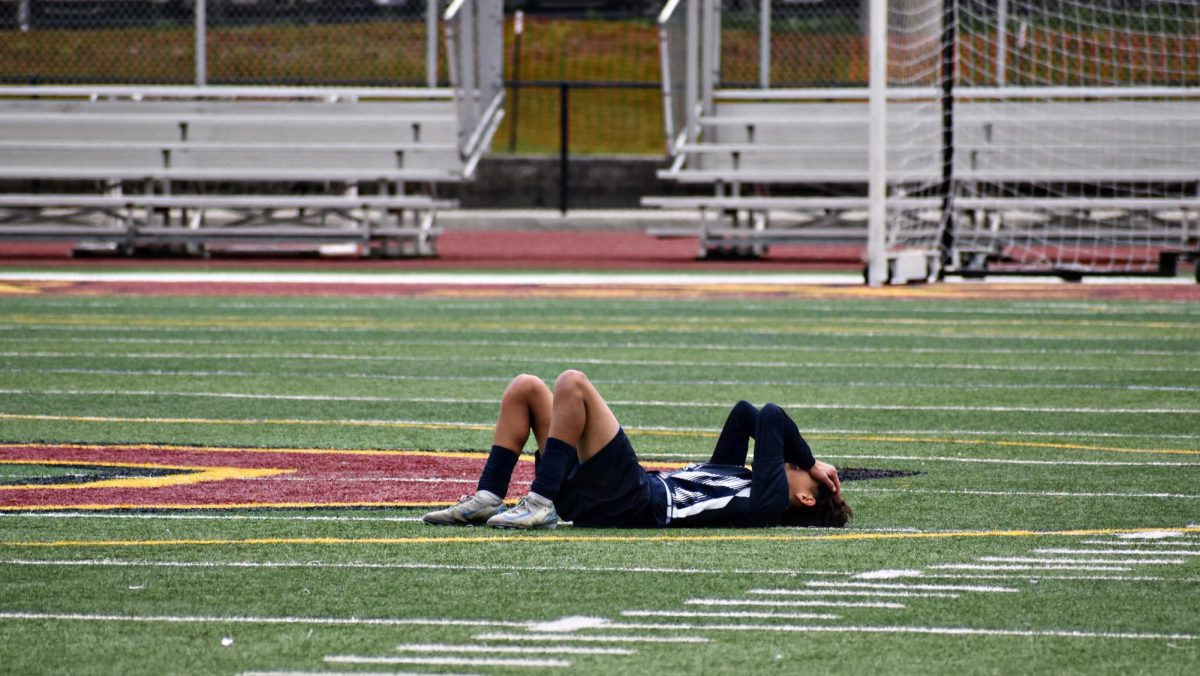 Senior Aiden Durbin lies in distraught on the field after finishing his final soccer game as a Wildcat. 