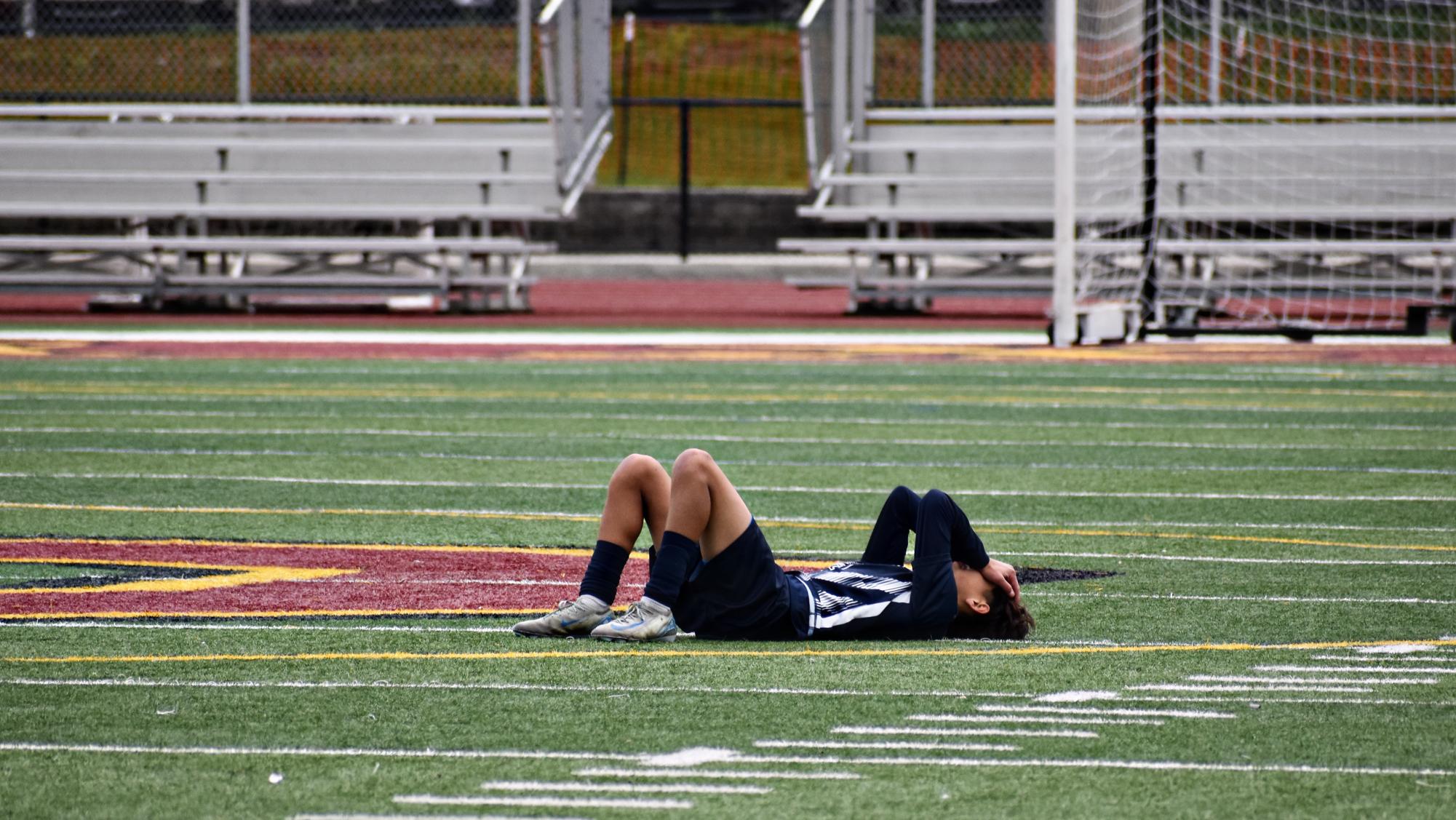 Senior Aiden Durbin lies in distraught on the field after finishing his final soccer game as a Wildcat. 