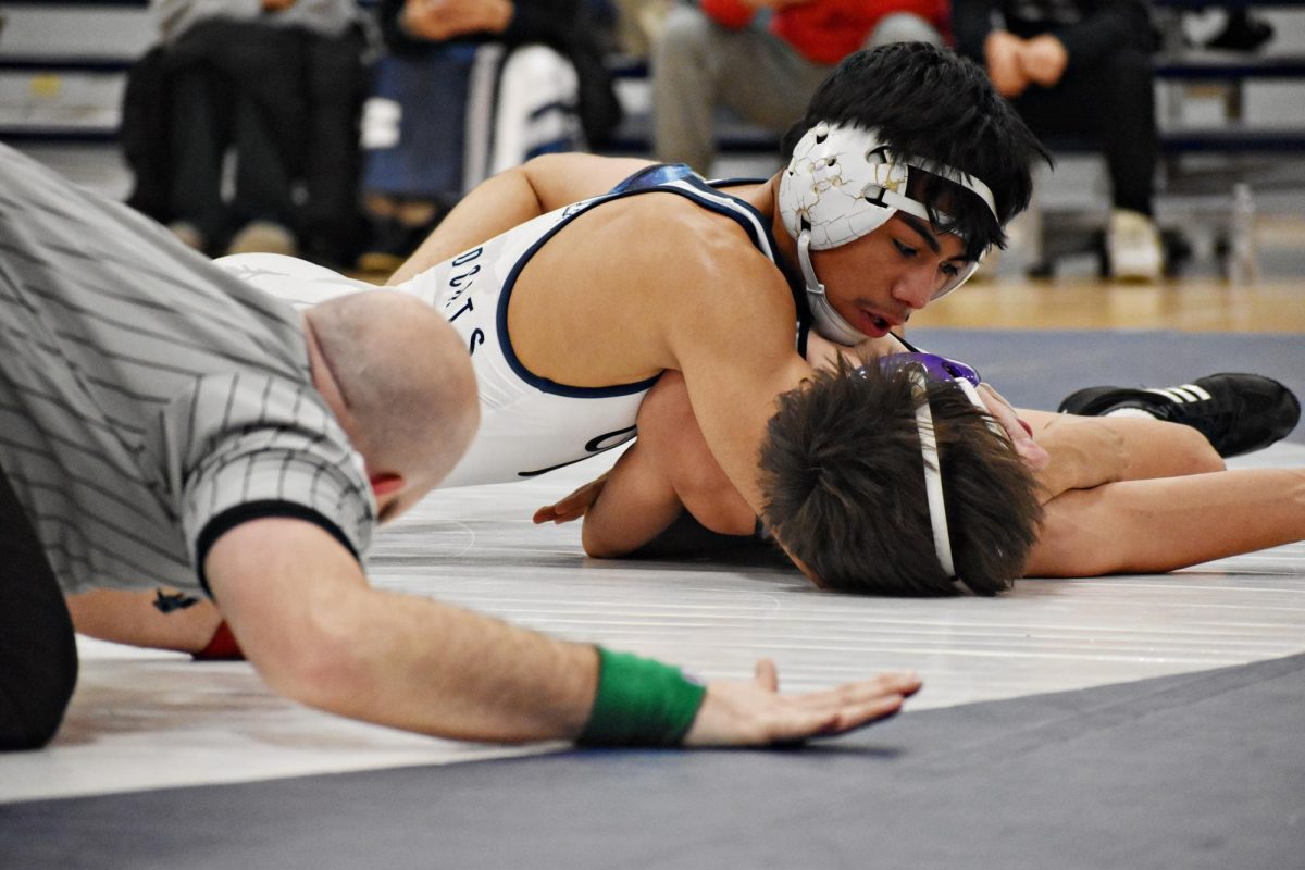Junior Emy Rangel pins down his opponent in the final second of the match, securing  the win.