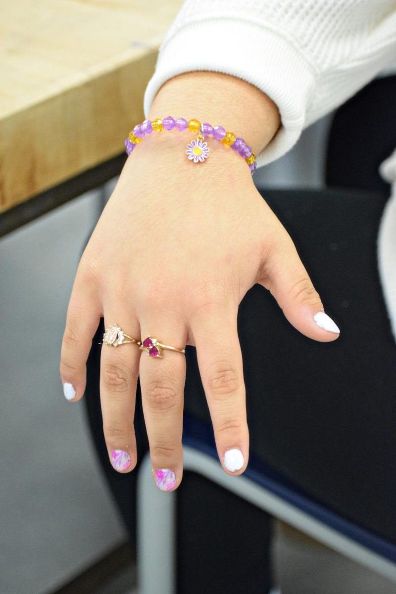 An Art Club member models one of the bracelets available for sale this December; Art Club spent over a month preparing for the fundraiser.
