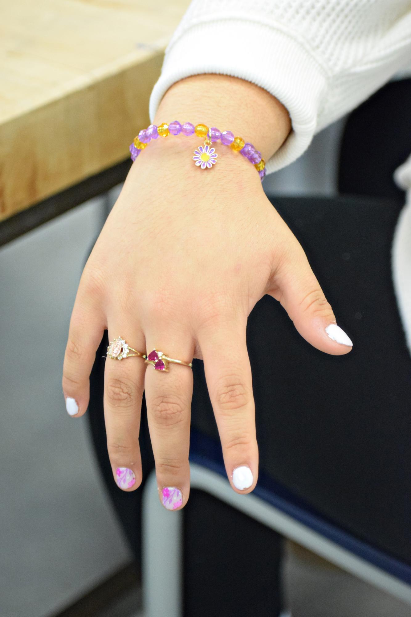 An Art Club member models one of the bracelets available for sale this December; Art Club spent over a month preparing for the fundraiser.