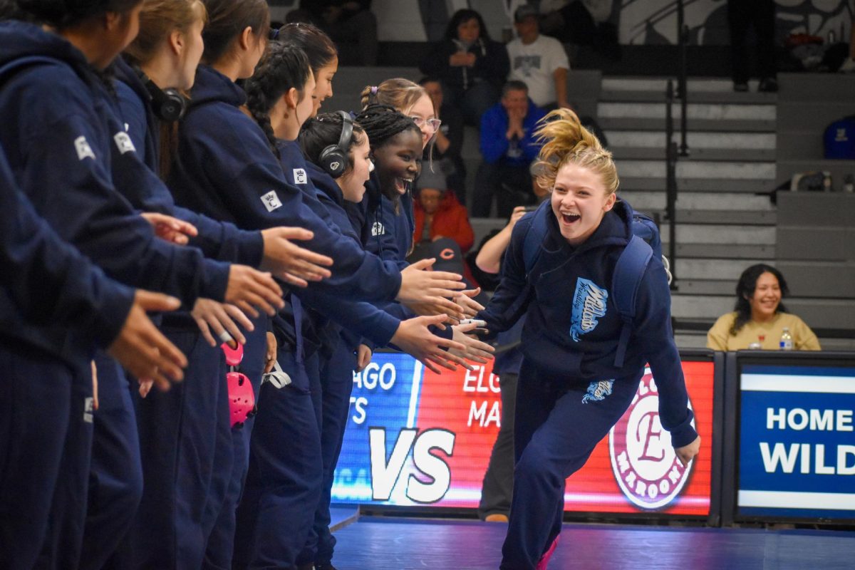 On Dec. 3, the West Chicago girls' wrestling team took the mat to assert their dominance. Junior Mackensie Szajda is welcomed in by her teammates. 