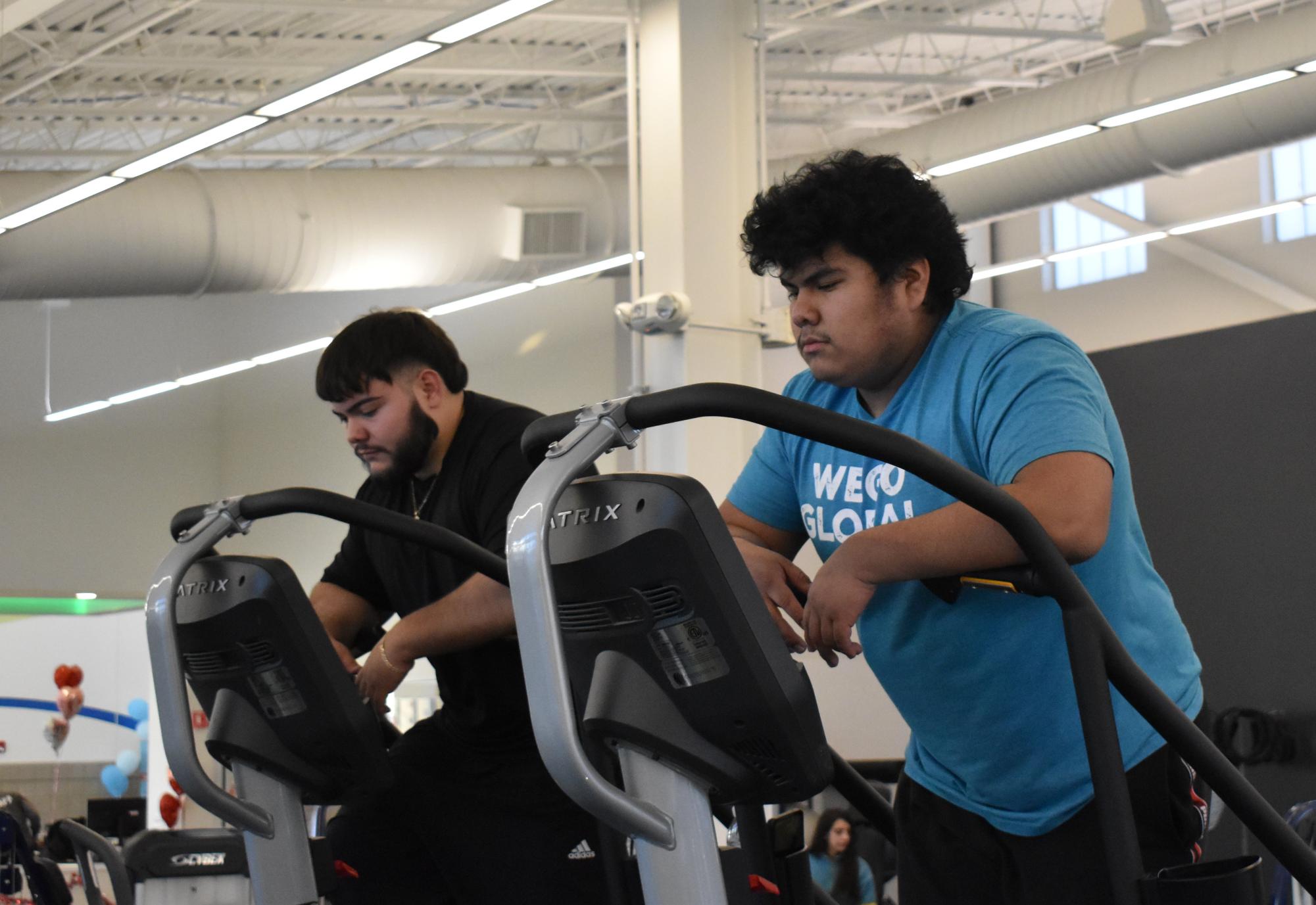 Seniors Alex Hernandez and Adrian Alanis are using the StairMaster at the ARC Center in West Chicago after school in February 2026 to help cut calories.