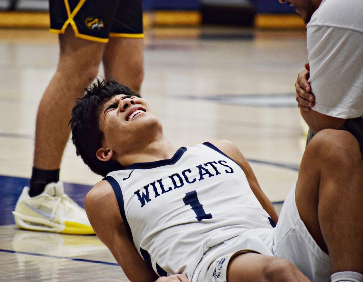 Senior AJ Rotger lies on the ground in pain after a foul in the fourth quarter.