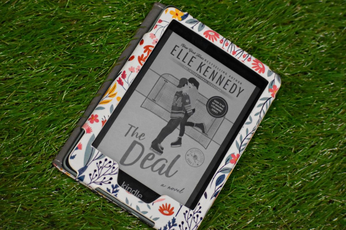 Pictured is "The Deal" by Elle Kennedy on an Amazon Kindle. Here, Garrett Graham embraces Hannah Wells at the rink.