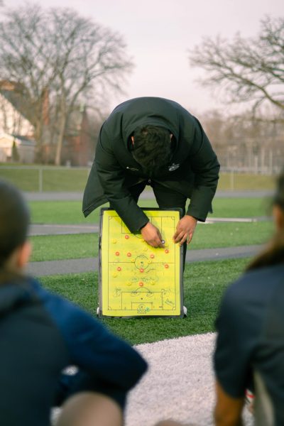 Assistant coach Dorian Carrasco gives tactical advice during halftime, as the team listens attentively on March 20.