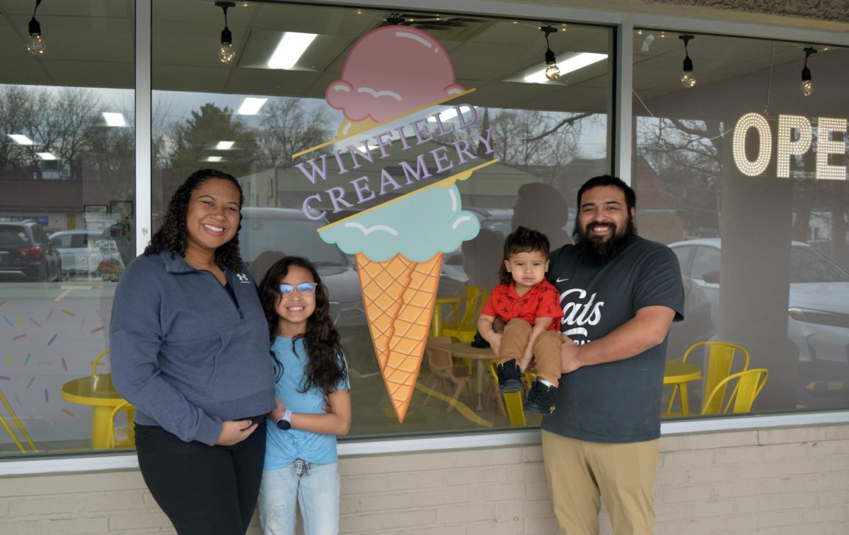 Winfield Creamery owners Katrina and David Muenster pose with their children outside the shop’s storefront in downtown Winfield. The family opened the business in December 2025 to create a community gathering space centered around ice cream.