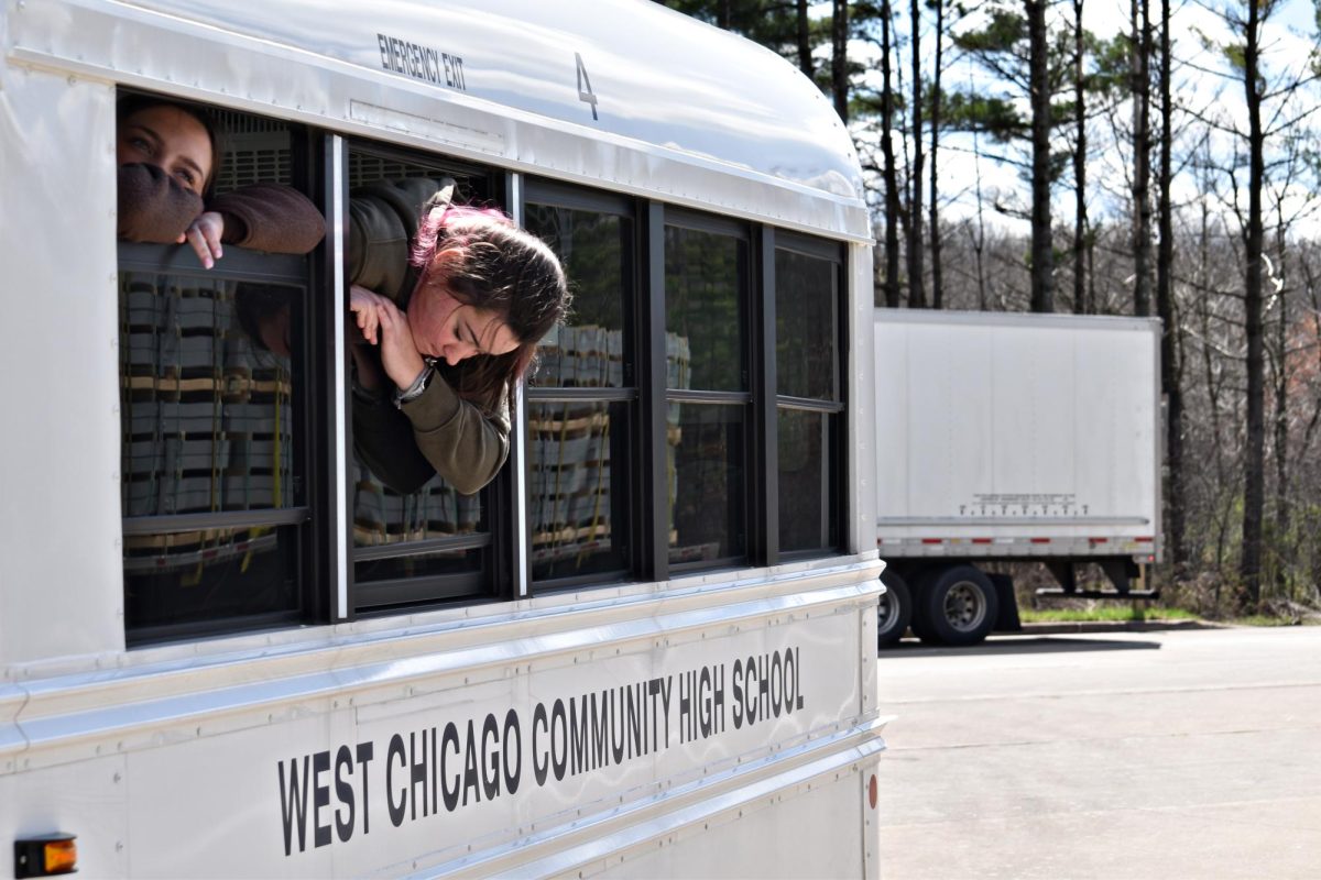 Seniors Aly Dusing and Miley Pegg look out from the minibus window while stopped at a rest area in Lyndon Station, Wis., on April 19 following a mechanical issue that delayed the group’s return from Minneapolis.