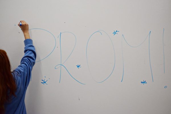 Sophomore Evelyn Mondragon writes “prom” on a whiteboard ahead of West Chicago Community High School’s prom season in May 2026. Discussions surrounding the future of WEGO’s downtown prom tradition have sparked strong reactions from students.